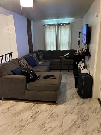 a living room with furniture window and dresser