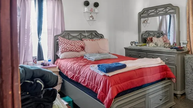 a bedroom with a bed and window