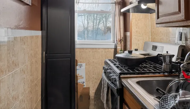 a kitchen with a sink and a stove next to a window