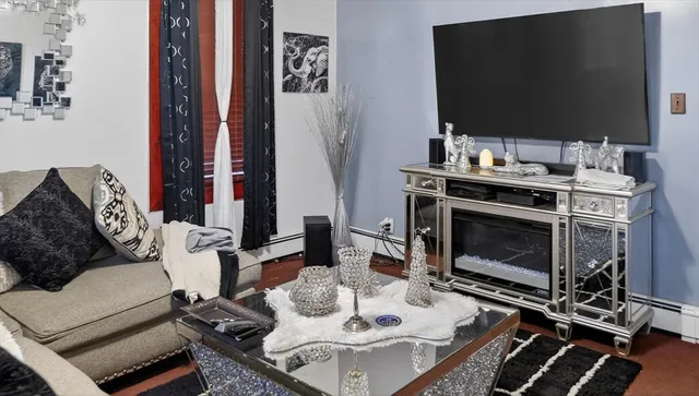 a living room with furniture a flat screen tv and a fireplace