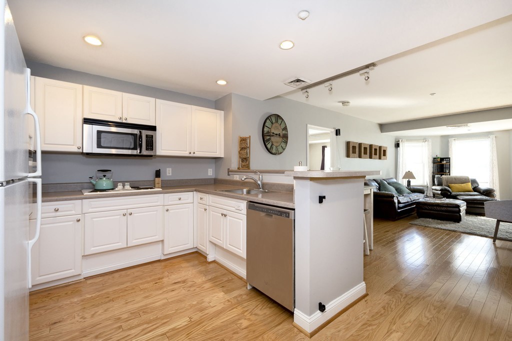 a kitchen with a sink cabinets and wooden floor