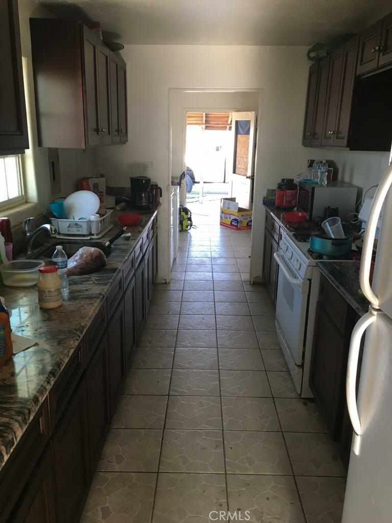 37712 210th Street East Palmdale, CA 93591 - Photo 7 of 12 a kitchen with stainless steel appliances granite countertop a stove a sink and a microwave