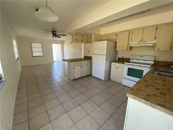 a kitchen with granite countertop a refrigerator and a stove top oven