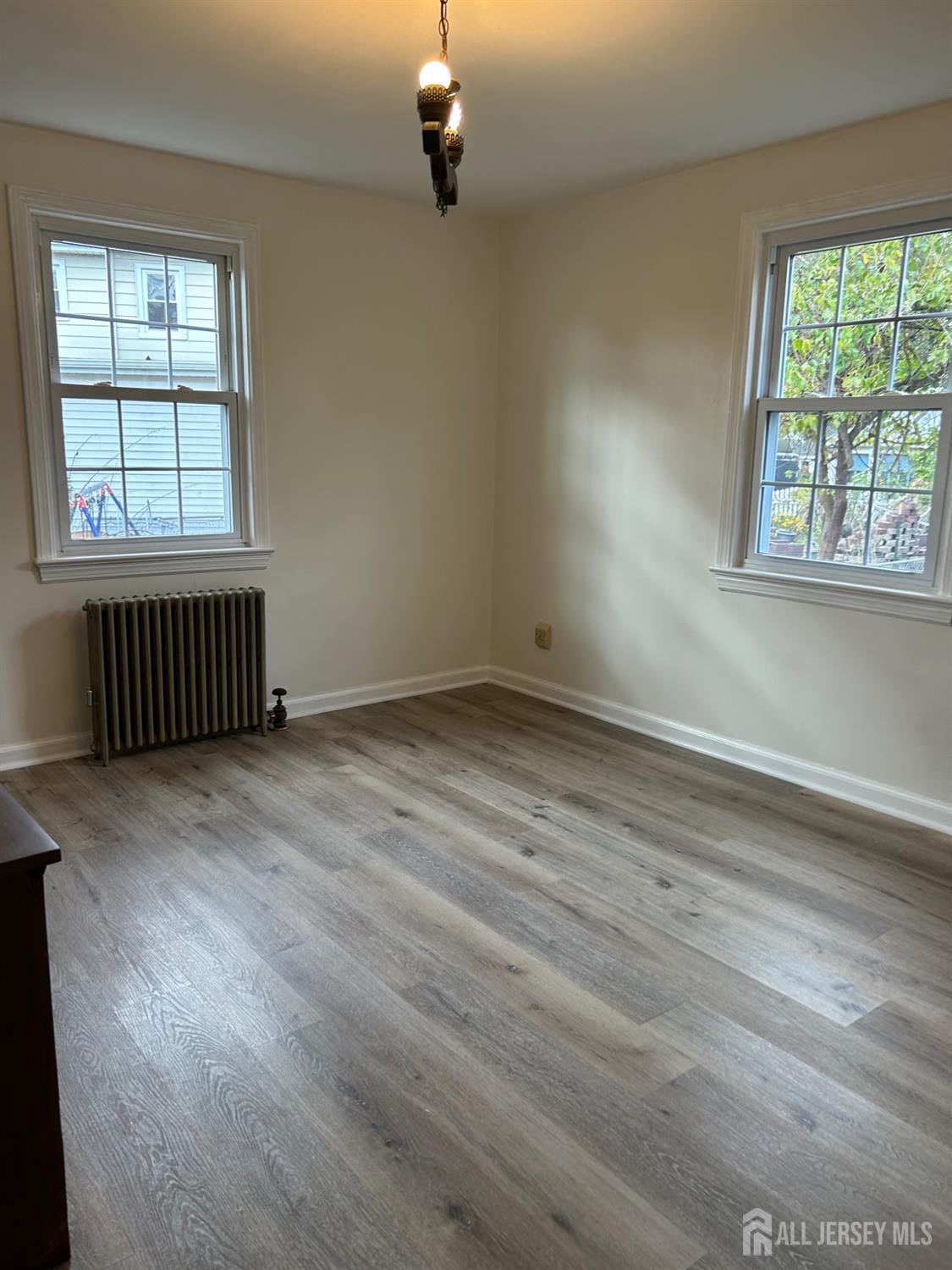 518 2nd Street Dunellen, NJ 08812 - Photo 10 of 14 an empty room with wooden floor and windows