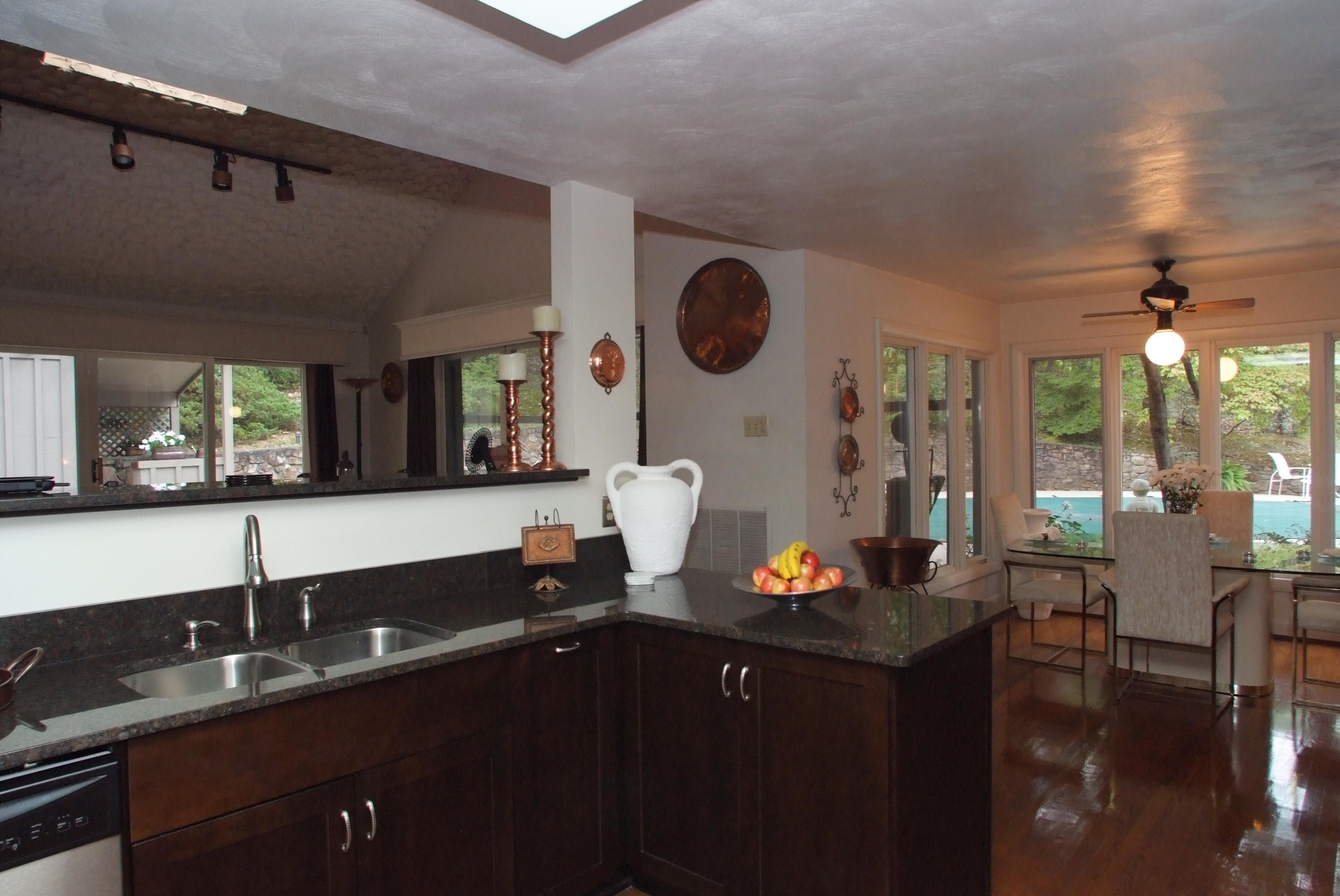 4838 Deerfield Road Southwest Roanoke, VA 24018 - Photo 12 of 26 a kitchen with a sink dishwasher a stove and chairs with wooden floor