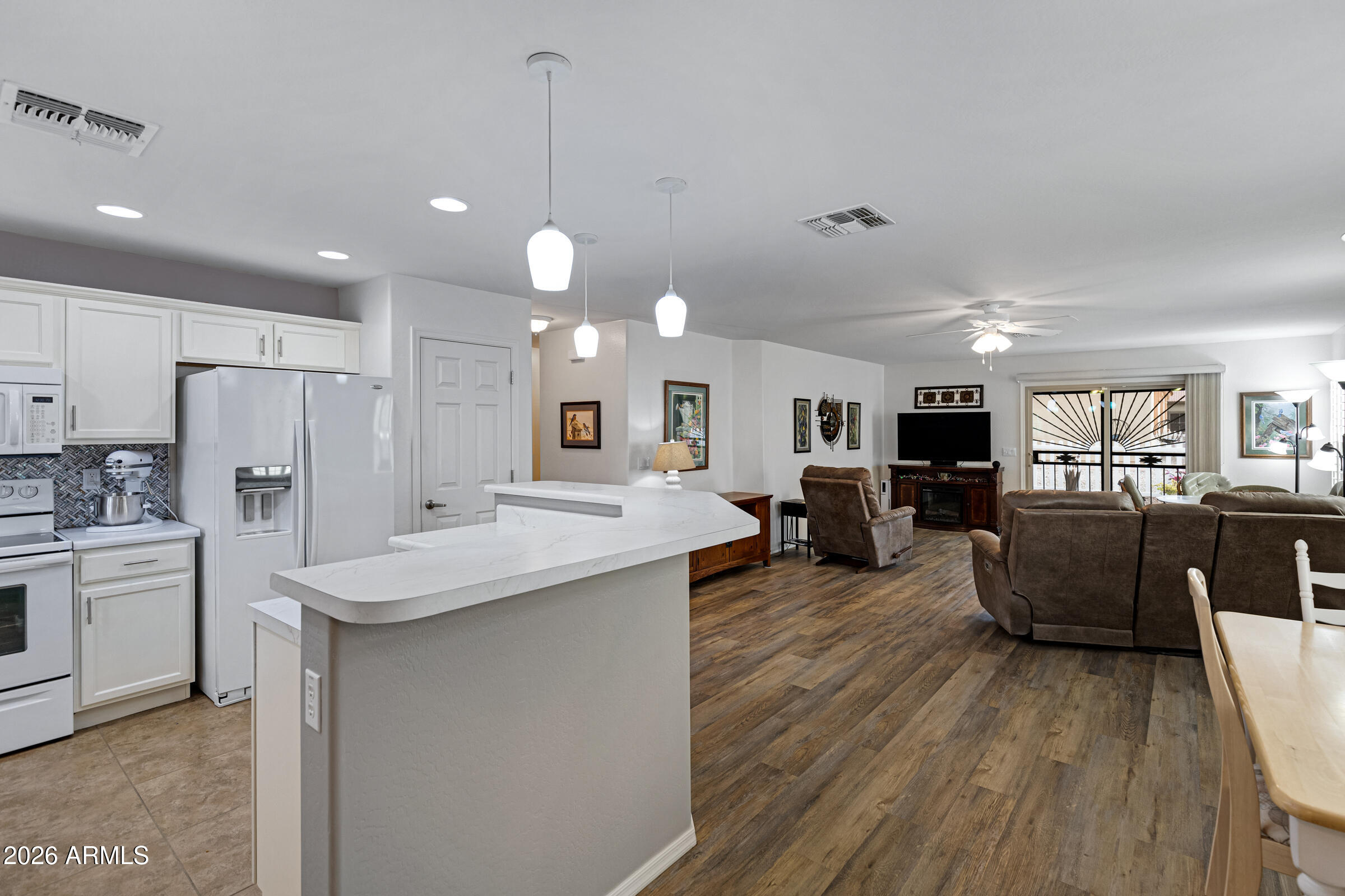 2101 South Meridian Road, Unit 199 Apache Junction, AZ 85120 - Photo 6 of 26 a large kitchen with kitchen island a sink a center island stainless steel appliances and a fireplace