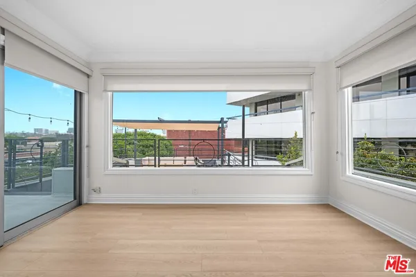 a view of a big room with wooden floor and windows