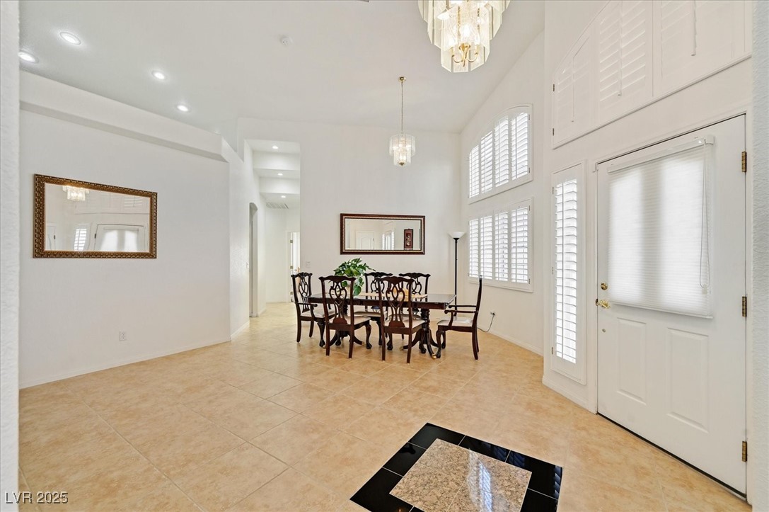 6120 Farm Road Las Vegas, NV 89131 - Photo 4 of 30 Dining area featuring light tile patterned flooring, recessed lighting, a towering ceiling, and a chandelier