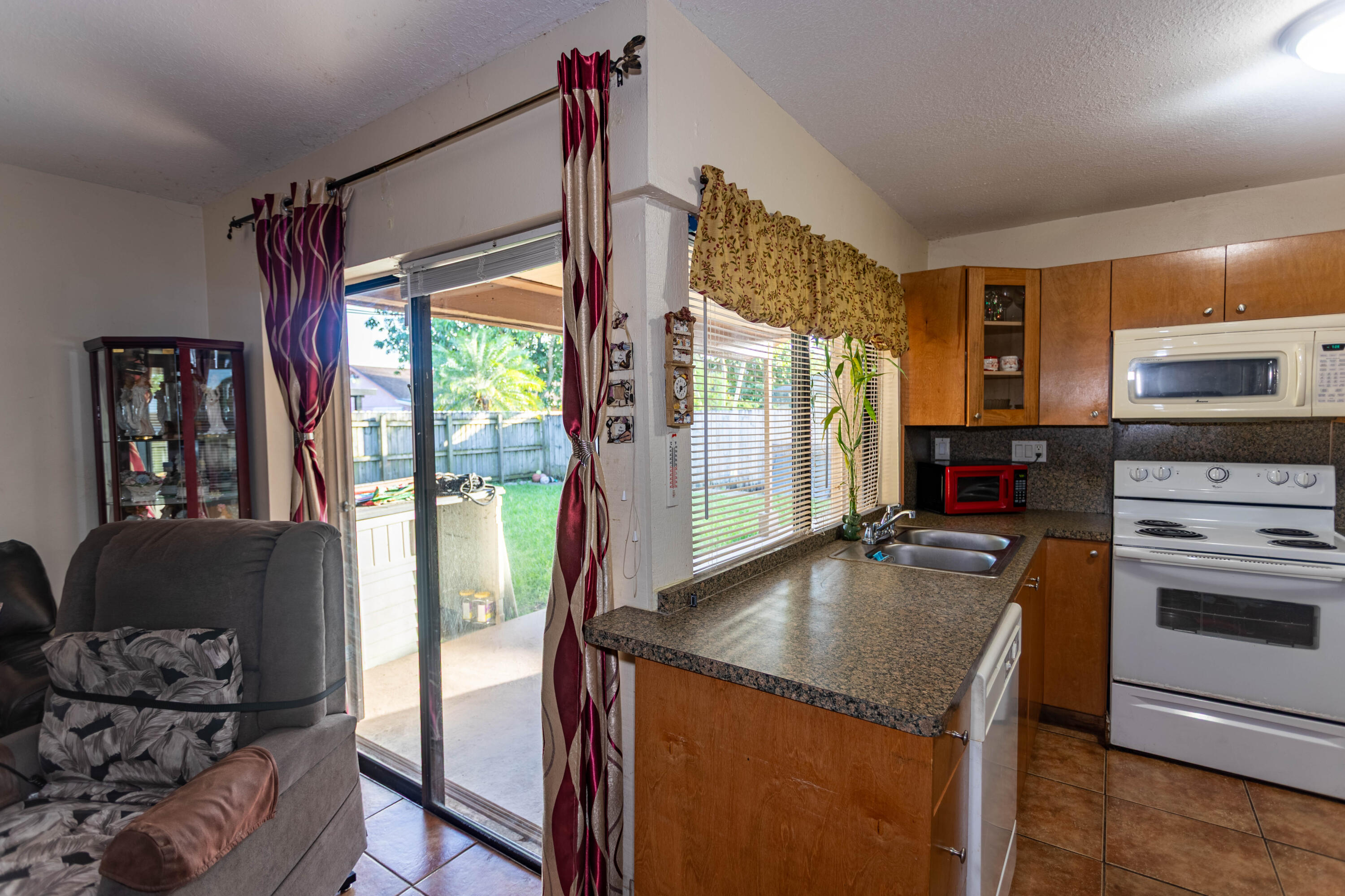 11210 Southwest 157th Street Miami, FL 33157 - Photo 42 of 55 a kitchen with granite countertop a stove and a refrigerator
