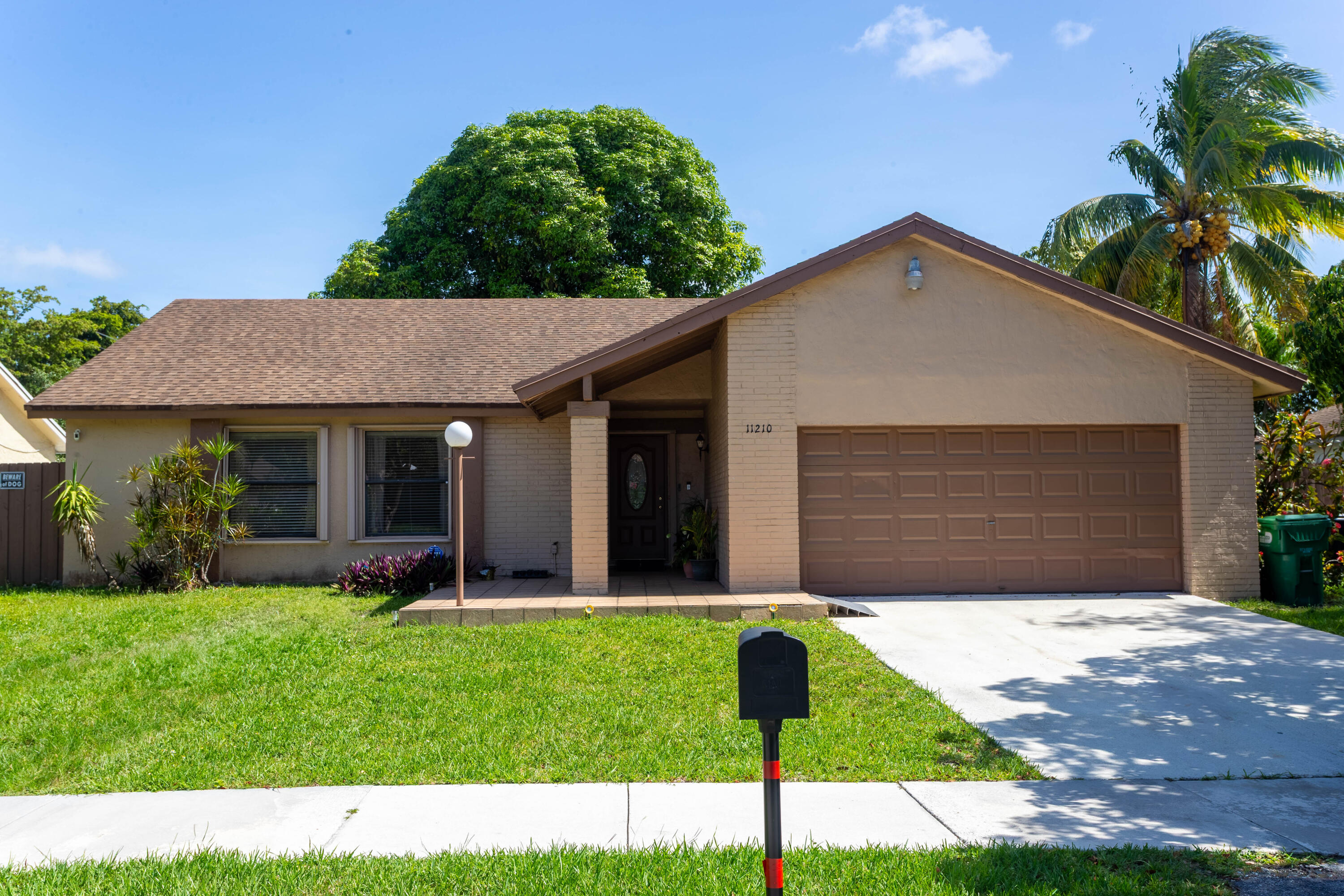 11210 Southwest 157th Street Miami, FL 33157 - Photo 5 of 55 a front view of a house with a yard and garage