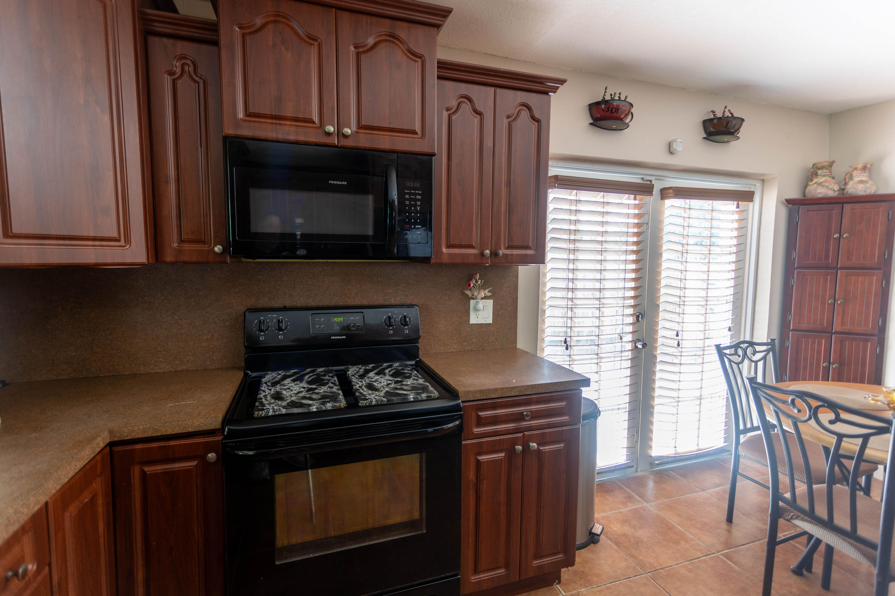 11210 Southwest 157th Street Miami, FL 33157 - Photo 10 of 55 a kitchen with granite countertop a stove top oven microwave and cabinets