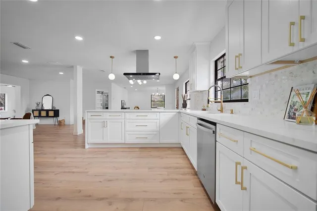 a kitchen with stainless steel appliances a sink and a chandelier
