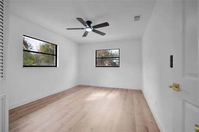a view of a big room with wooden floor closet and windows