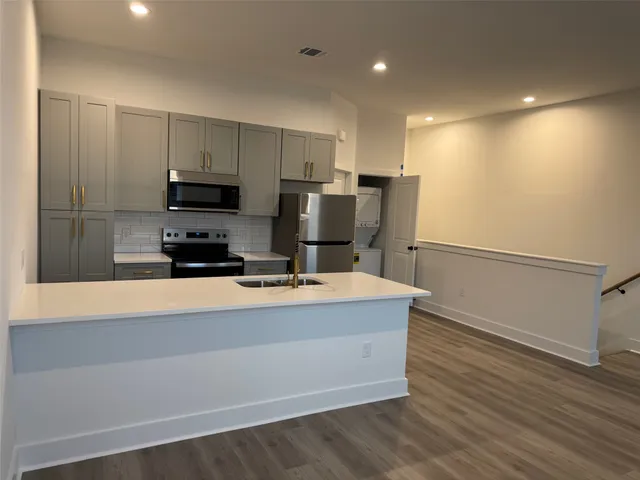 a kitchen with stainless steel appliances a refrigerator and a stove top oven