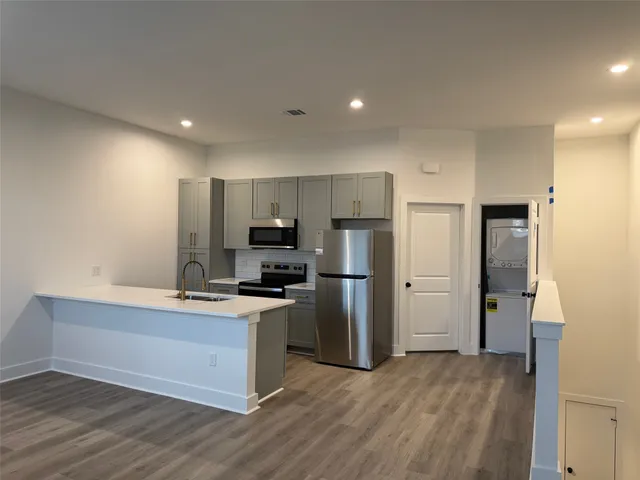 a kitchen with refrigerator cabinets and wooden floor