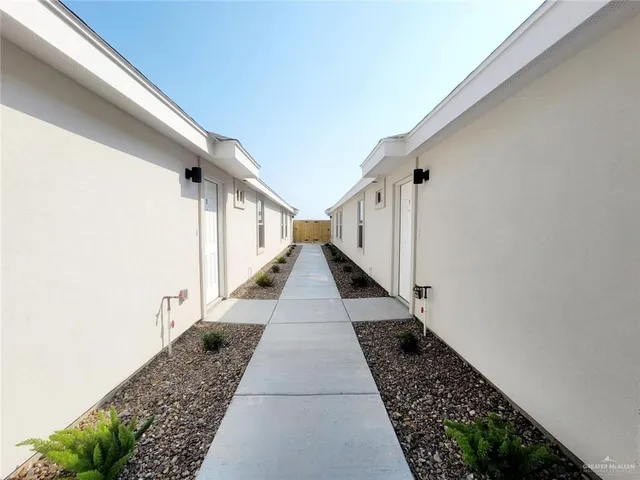 a view of a pathway with white walls