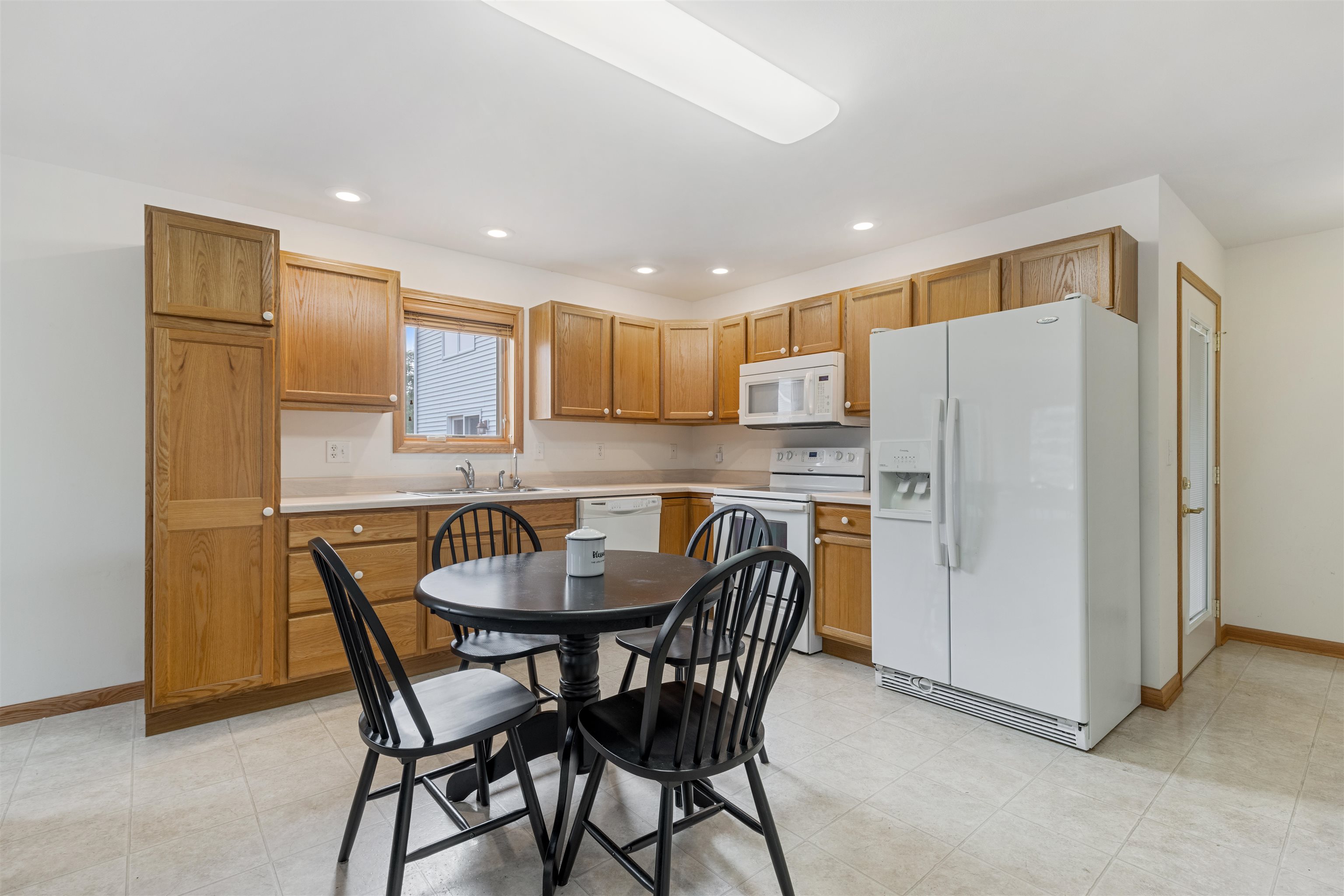 8609 South Rood Road Kingston, IL 60145 - Photo 19 of 39 a kitchen with a refrigerator a dining table and chairs