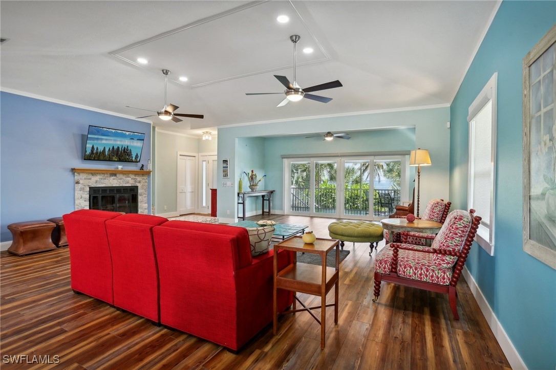 8335 Main Street Bokeelia, FL 33922 - Photo 16 of 47 a living room with furniture a fireplace and a floor to ceiling window