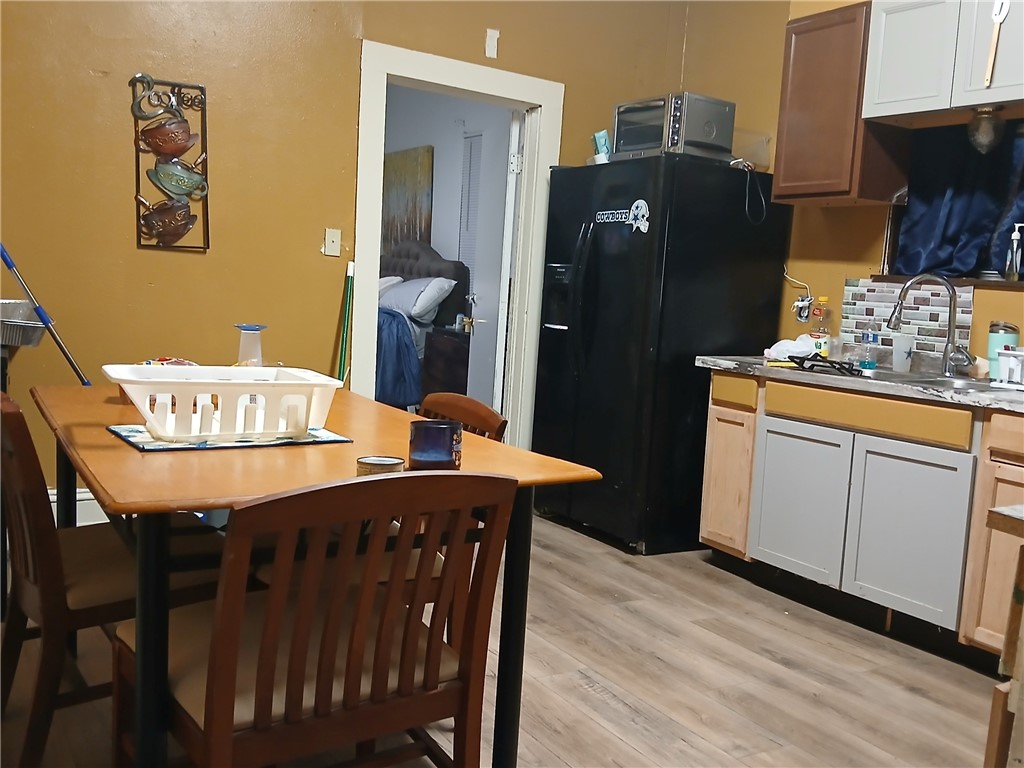 921 Preston Street Waco, TX 76704 - Photo 6 of 6 a kitchen with stainless steel appliances granite countertop a dining table chairs refrigerator and cabinets