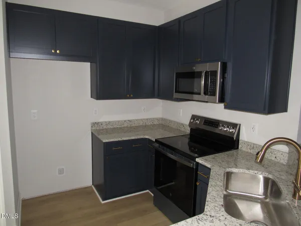 a kitchen with granite countertop a stove and a microwave