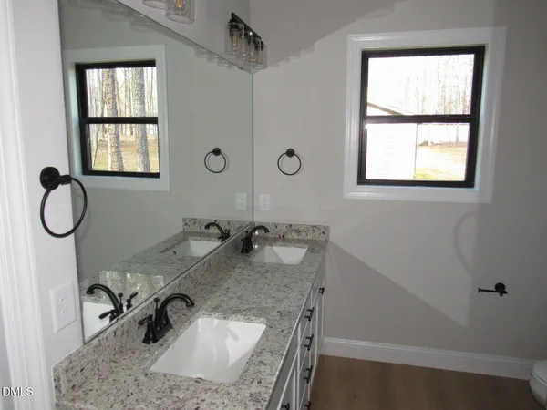a bathroom with a granite countertop sink and a window