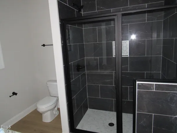a bathroom with a toilet and a shower