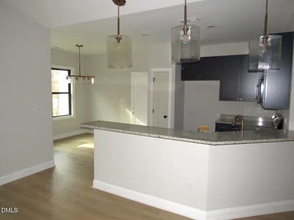 a view of a kitchen with a sink and dishwasher with wooden floor