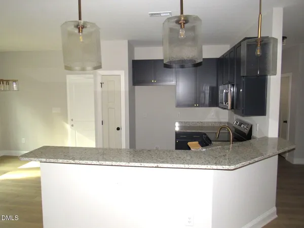 a kitchen with granite countertop a sink stainless steel appliances and cabinets