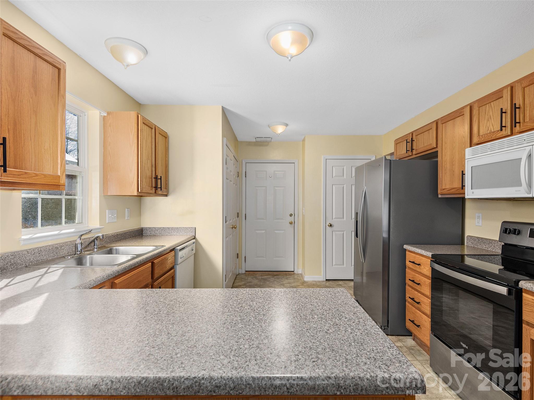 88 Wiltshire Circle Fletcher, NC 28732 - Photo 7 of 16 a kitchen with granite countertop a sink and a stove top oven with wooden floor