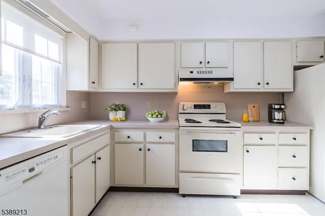 a kitchen with white cabinets and white appliances
