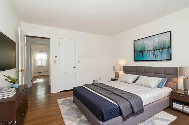 a bedroom with a large bed and a painting on the wall