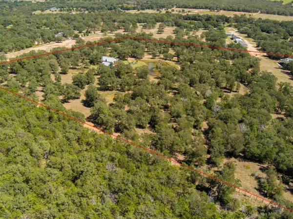 an aerial view of residential houses with outdoor space and trees