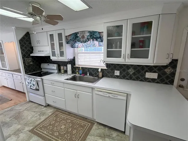a kitchen with granite countertop a stove a sink and a microwave