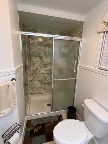 a bathroom with a toilet and a shower