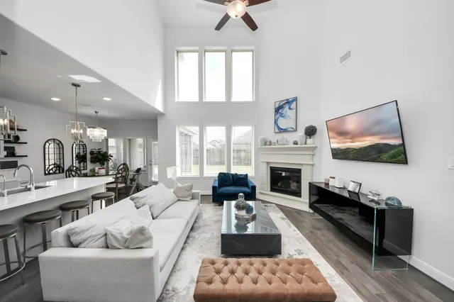 a living room with furniture fireplace and a large window