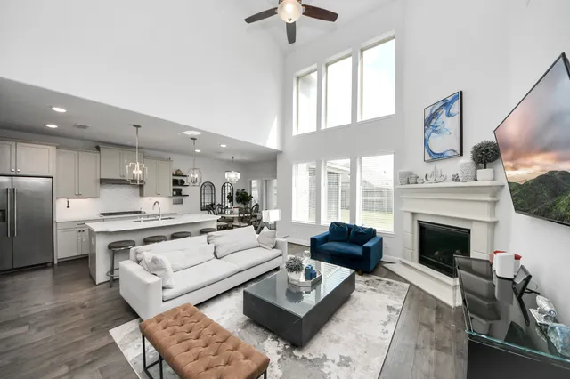 a living room with furniture fireplace and a large window