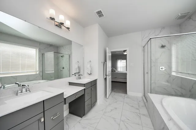 a spacious bathroom with a tub shower and a sink