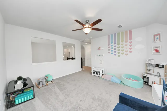a living room with a baby crib and a dresser