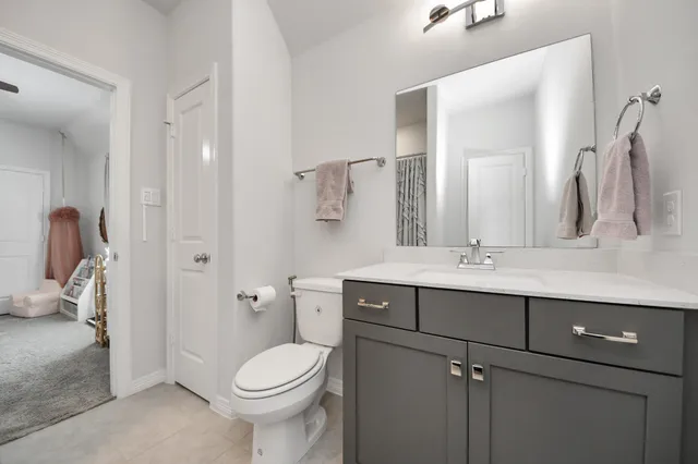 a bathroom with a granite countertop toilet a sink and a mirror