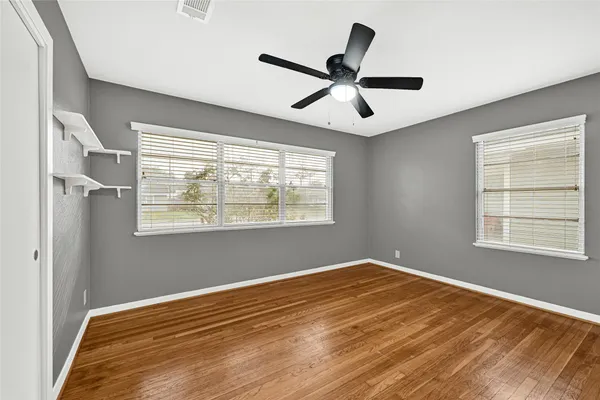 a view of a big room with wooden floor and windows