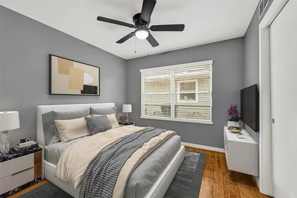 a bedroom with bed tv and window