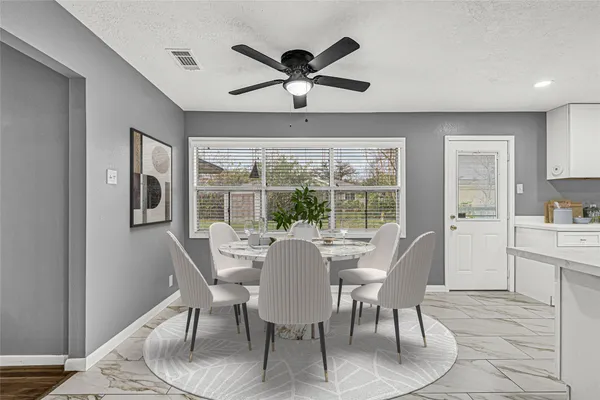 a dining room with furniture a rug and a large window