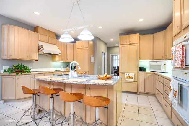 a kitchen with stainless steel appliances kitchen island granite countertop a sink and cabinets