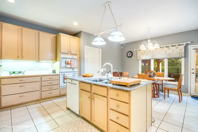 a kitchen with a stove a sink a dining table and chairs
