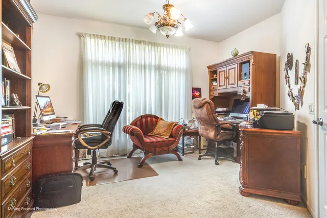 a view of a livingroom with workspace and a window