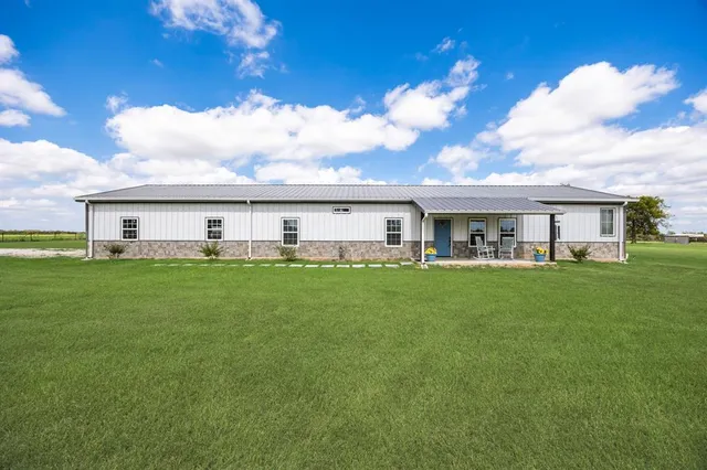 a front view of house with yard barbeque and outdoor seating
