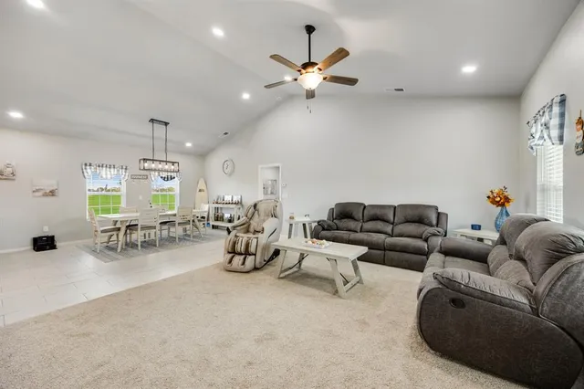 a living room with furniture and a flat screen tv with kitchen view