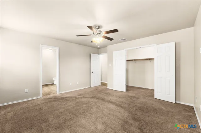 an empty room with fan and a ceiling fan