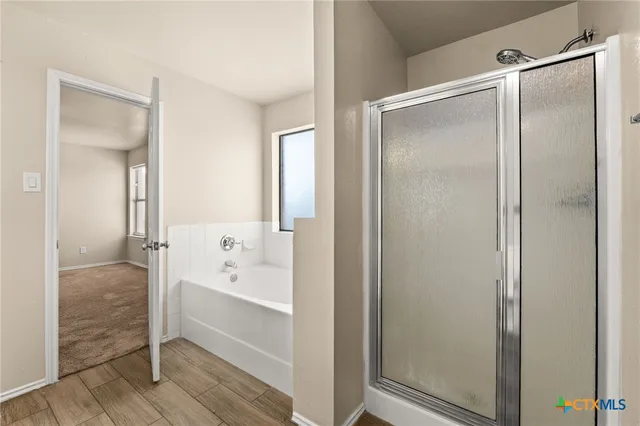 a bathroom with a glass shower door and a bathtub