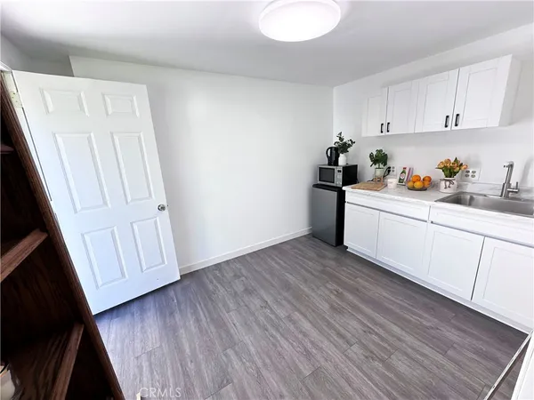 a kitchen with wooden floor and cabinets